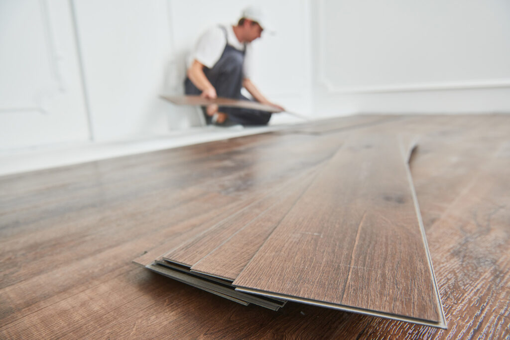 worker laying laminate flooring